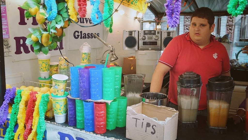 Vendor at colorful drinks stall